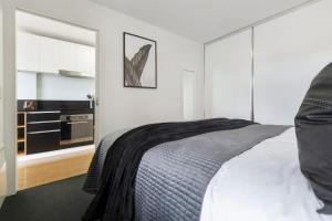 Un dormitorio blanco con una cama y una cocina. en VAQUAY Verge In Brunswick East, en Melbourne