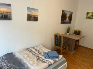 a room with a bed and a desk with pictures on the wall at Gästewohnung 1 OGL in der Nähe zur Veltinsarena - Gästewilli 3 in Gelsenkirchen