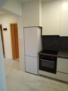 a kitchen with a white refrigerator and a stove at Apartman Pavic in Pag
