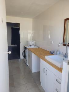 a white kitchen with a sink and a counter at Kalbarri Seaview Villas in Kalbarri +37 photos