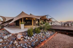 a house in the middle of the desert with a deck at Desert Hills Glamping Camp in Sesriem