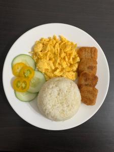 un plato blanco de comida con arroz y huevos en LS Garden Villa en Puerto Princesa