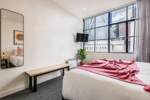 メルボルンにあるVAQUAY Warehouse 33 In Melbourne CBDのベッドと鏡のあるホテルの部屋