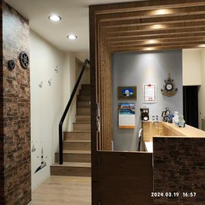 een hal met een trap en een deur naar een kamer bij 星語采居民宿 in Magong