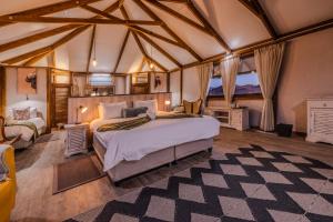 um quarto com uma cama grande numa tenda em Desert Hills Glamping Camp em Sesriem