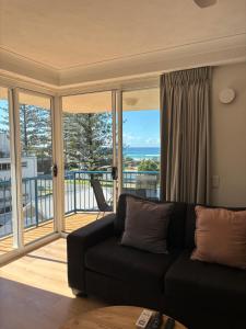 sala de estar con sofá y balcón en San Mateo On Broadbeach, en Gold Coast