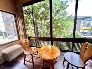 a room with two chairs and a table in front of a window at 日本旅館　松亀荘 in Beppu