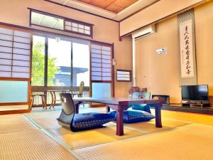 Pokój ze stołem i krzesłami oraz telewizorem w obiekcie 日本旅館　松亀荘 w mieście Beppu