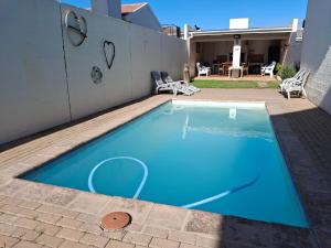 a small blue swimming pool in a backyard at DolfinHouse in Yzerfontein