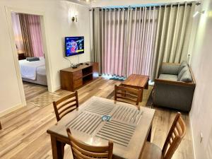 uma sala de estar com uma mesa, um sofá e uma televisão em Lake View Residencies em Nuwara Eliya