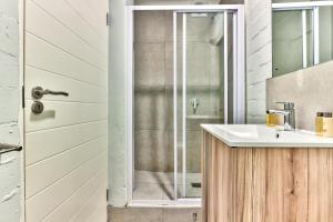 uma casa de banho com um lavatório e um chuveiro em WINK Aparthotel Eaton Square na Cidade do Cabo