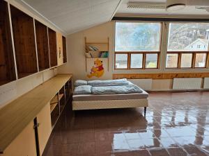1 dormitorio con 1 cama en una habitación con ventanas en Brufjell Hostel & Parking, en Flekkefjord