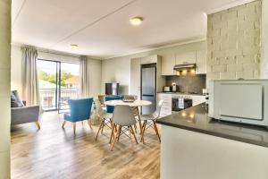 uma cozinha e sala de estar com mesa e cadeiras em WINK Aparthotel Eaton Square na Cidade do Cabo