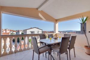 Un patio con una mesa y sillas en un balcón. en Apartman Dina, en Zadar