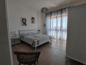 a bedroom with a bed and a large window at Villetta Scruscio ri Mare in Favignana