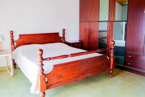 a wooden bed in a bedroom with wooden cabinets at Casa in zona residenziale in Nettuno