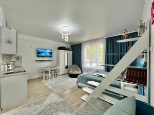 Raduga West 'Azure' Apartment في Koshkolʼ: غرفة نوم مع سرير وغرفة معيشة