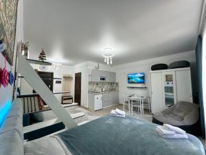 ein Schlafzimmer mit Bett und eine Küche mit Tisch in der Unterkunft Raduga West 'Azure' Apartment in Koshkolʼ