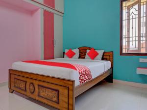 Sharin Service Apartments في سالم: غرفة نوم بسرير بجدران حمراء وزرقاء