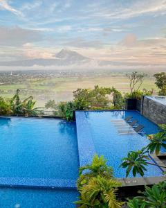 una piscina con vistas a la montaña en Amaranta Prambanan Yogyakarta en Yogyakarta