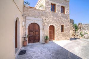 un edificio de piedra con una gran puerta de madera en Askoutsi Manor, a Natural Tranquil Retreat, By ThinkVilla, en Áyios Ioánnis