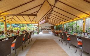 um restaurante com tectos e mesas e cadeiras de madeira em Bedzzz Xclusiv Baikunth, Manali By Leisure Hotels - 650 meters from Hidimba Devi Temple em Manali