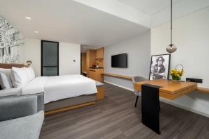 a hotel room with a bed and a desk at UrCove by Hyatt Guangzhou Tower Pazhou Exhibition Center in Guangzhou