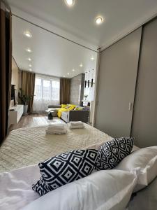 um quarto com uma cama grande e um sofá em Apartament Almaty Akvarel em Almaty
