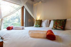 a white bed with pillows on it with a window at Bush Villas on Kruger in Phalaborwa