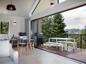 a patio with a table and chairs and a grill at Jacks Lodge Townhouse in Hanmer Springs