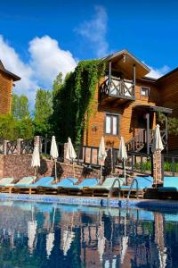 un complejo con una piscina con sombrillas en Boutigue Hotel Nebesa, en Chimgan