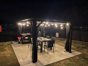 a gazebo with a table and chairs under it at night at Hau'oli in Awaji
