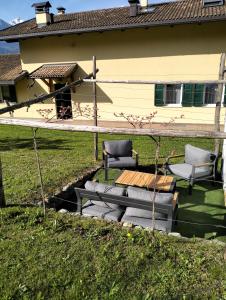 a patio with two chairs and a table and a bench at B&B Elisè in Castel Ivano