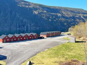 a row of red buildings next to a body of water at 19 person holiday home in Jøsenfjorden-By Traum in Gullingen