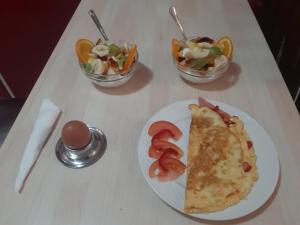 une table avec une assiette de nourriture et des bols de salade dans l'établissement Paraskevi's Luxury Studios, à Parga