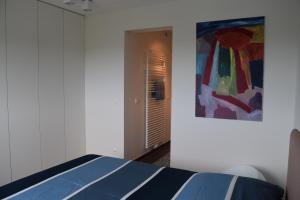 ニーウポールトにあるKarthuizer duinzichtのベッドルーム1室(ベッド1台付)が備わります。壁には絵画が飾られています。