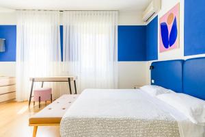 a blue and white bedroom with a bed and a table at Hotel Il Nido in Tellaro