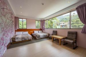 Schlafzimmer mit einem Bett, einem Schreibtisch und einem Stuhl in der Unterkunft 溪頭老爺山莊Xitou Royal Villa in Lugu