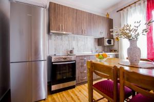 a kitchen with a table and a stainless steel refrigerator at Farma House Vasilo - Escape Cottage Retreat in Evkarpía