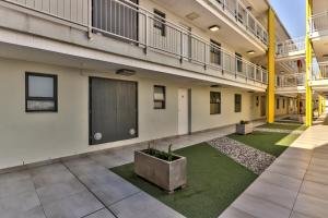 an empty building with a courtyard with a large building at WINK Aparthotel Eaton Square in Cape Town