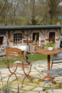 een tafel en een stoel naast een tafel en een huis bij Kunsthof Salsitz in Lohme