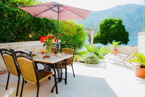 een tafel en stoelen met een parasol op een patio bij Three Dots by Todorovic Family in Kotor
