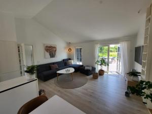 sala de estar con sofá y mesa en Sommerhus ved Mossø med søkig en Skanderborg