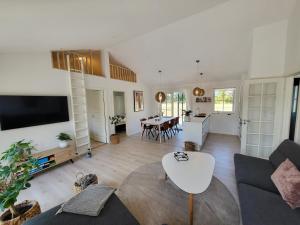 sala de estar con sofá y mesa en Sommerhus ved Mossø med søkig en Skanderborg