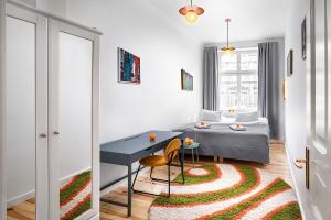 Cette chambre comprend un lit, une table et un tapis. dans l'établissement Apartamenty Pomarańczarnia, à Poznań