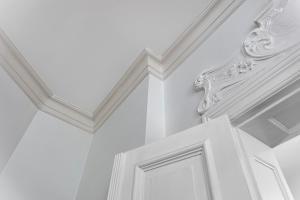 Cette chambre blanche dispose d'un plafond et d'une porte blancs. dans l'établissement Apartamenty Pomarańczarnia, à Poznań