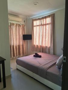 a bedroom with a bed and a window with pink curtains at RUMAH TAMU TEPI PANTAI in Dungun