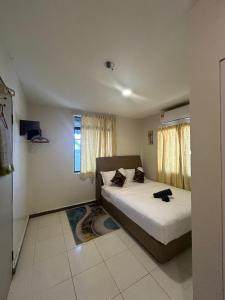 1 dormitorio con 2 camas y ventana en RUMAH TAMU TEPI PANTAI, en Dungun