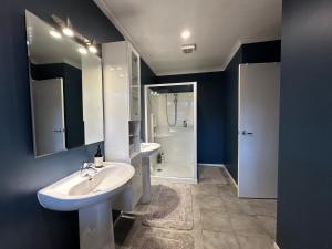 a bathroom with two sinks and a shower at Lakeview Holiday Hideaway in Taupo +23 photos