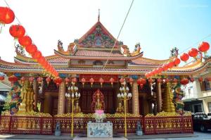 un edificio con un templo rojo y dorado en Caiyong Hometel & Cafe's Studio, en Khlong San